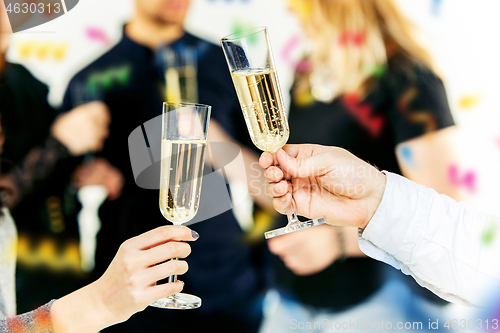 Image of Celebration. Hands holding the glasses of champagne and wine making a toast.