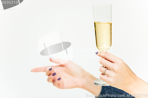 Image of Celebration. Female hands holding the glasse of champagne or wine making a toast.