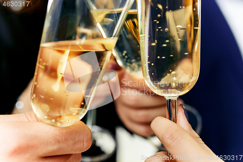 Image of Celebration. Hands holding the glasses of champagne and wine making a toast.