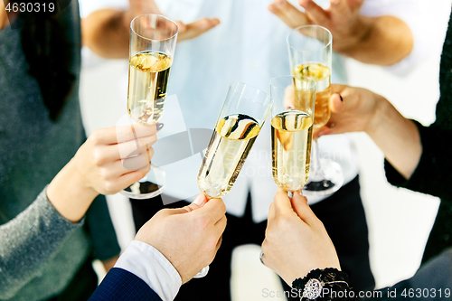 Image of Celebration. Hands holding the glasses of champagne and wine making a toast.