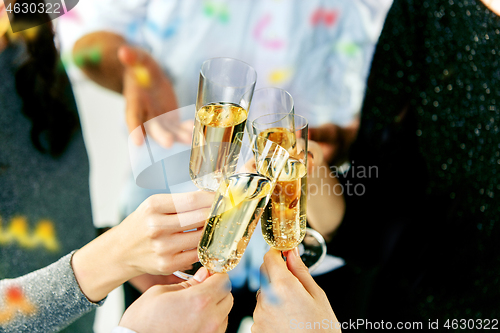 Image of Celebration. Hands holding the glasses of champagne and wine making a toast.