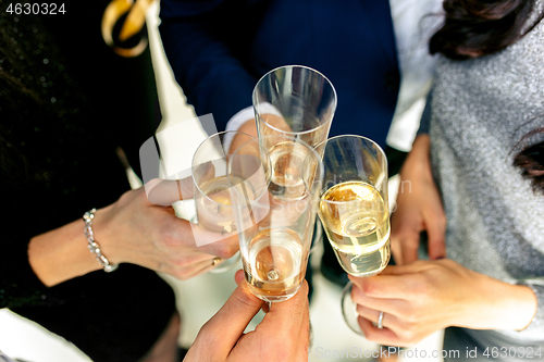 Image of Celebration. Hands holding the glasses of champagne and wine making a toast.