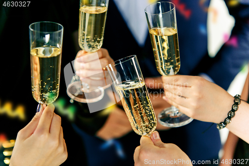 Image of Celebration. Hands holding the glasses of champagne and wine making a toast.