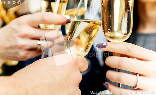 Image of Celebration. Hands holding the glasses of champagne and wine making a toast.