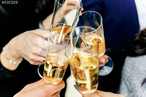 Image of Celebration. Hands holding the glasses of champagne and wine making a toast.