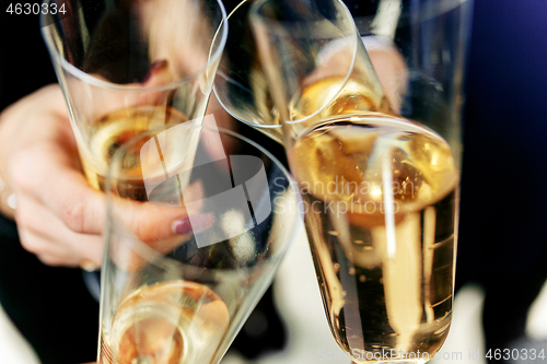 Image of Celebration. Hands holding the glasses of champagne and wine making a toast.