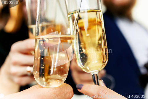 Image of Celebration. Hands holding the glasses of champagne and wine making a toast.