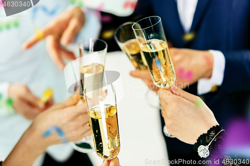 Image of Celebration. Hands holding the glasses of champagne and wine making a toast.