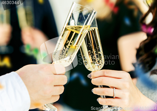 Image of Celebration. Hands holding the glasses of champagne and wine making a toast.