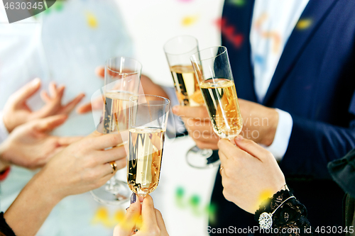 Image of Celebration. Hands holding the glasses of champagne and wine making a toast.