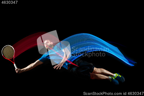 Image of one caucasian man playing tennis player on black background