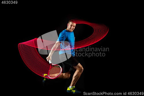 Image of one caucasian man playing tennis player on black background