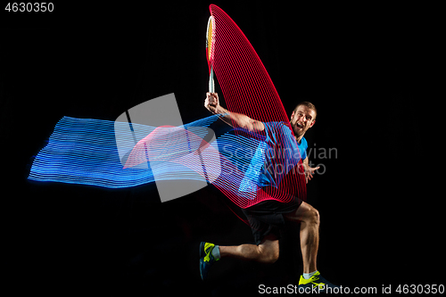 Image of one caucasian man playing tennis player on black background