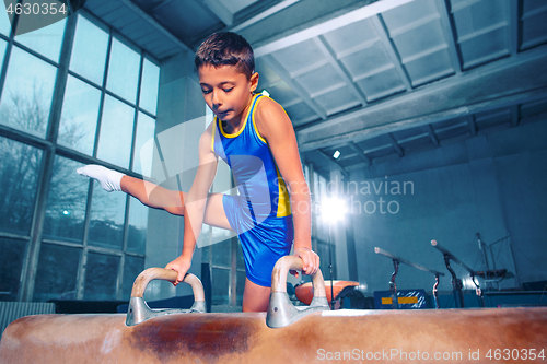 Image of The sportsman performing difficult gymnastic exercise at gym.