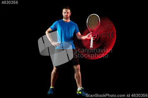 Image of one caucasian man playing tennis player on black background