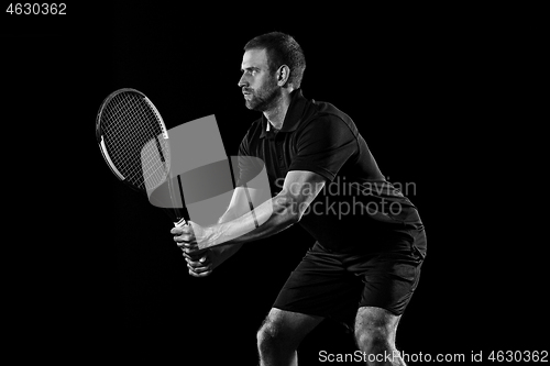 Image of one caucasian man playing tennis player on black background