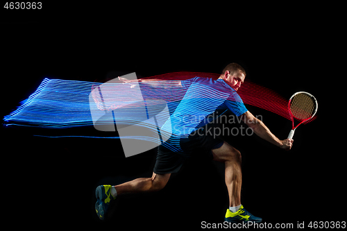 Image of one caucasian man playing tennis player on black background