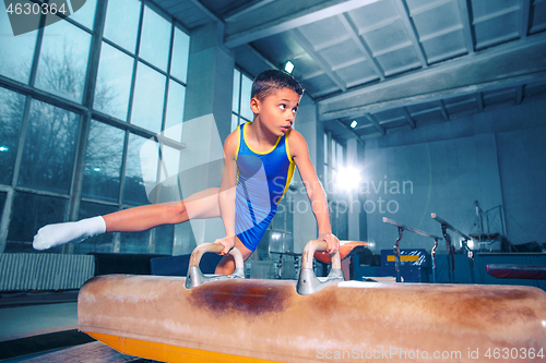 Image of The sportsman performing difficult gymnastic exercise at gym.