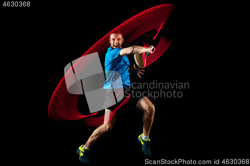 Image of one caucasian man playing tennis player on black background