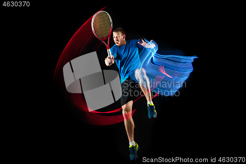 Image of one caucasian man playing tennis player on black background