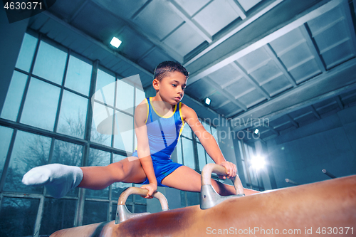 Image of The sportsman performing difficult gymnastic exercise at gym.