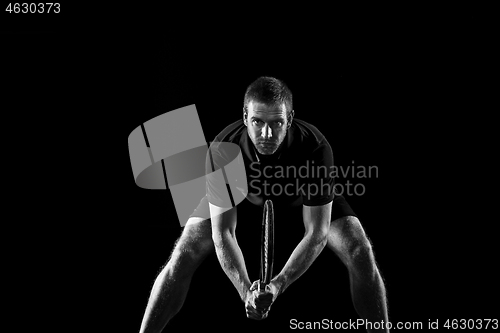 Image of one caucasian man playing tennis player on black background