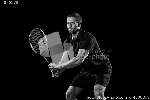 Image of one caucasian man playing tennis player on black background