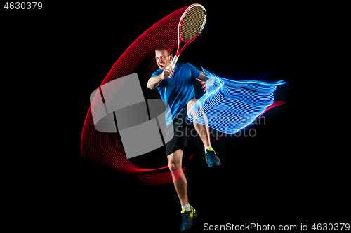 Image of one caucasian man playing tennis player on black background