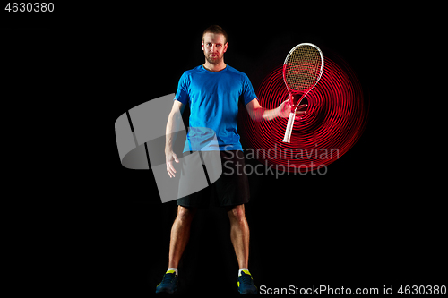 Image of one caucasian man playing tennis player on black background