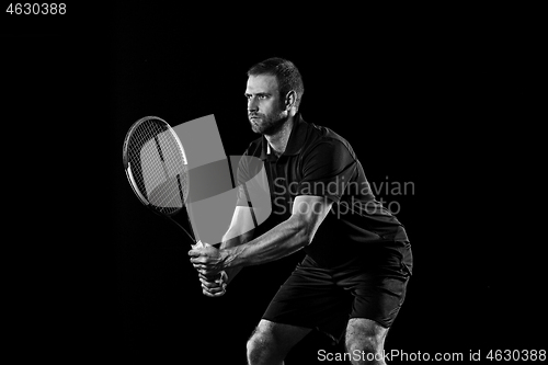 Image of one caucasian man playing tennis player on black background