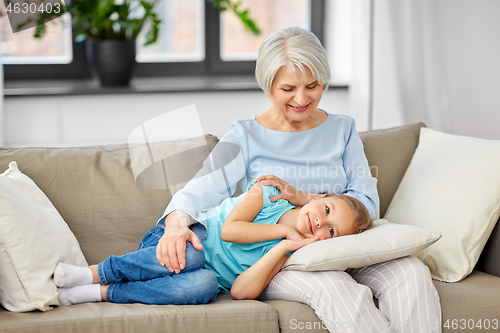 Image of grandmother and granddaughter resting on pillow