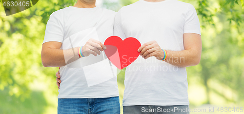 Image of couple with gay pride rainbow wristbands and heart