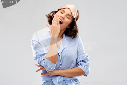 Image of happy young woman in pajama and eye sleeping mask