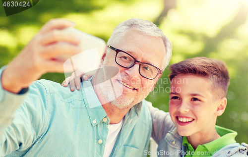 Image of old man and boy taking selfie by smartphone