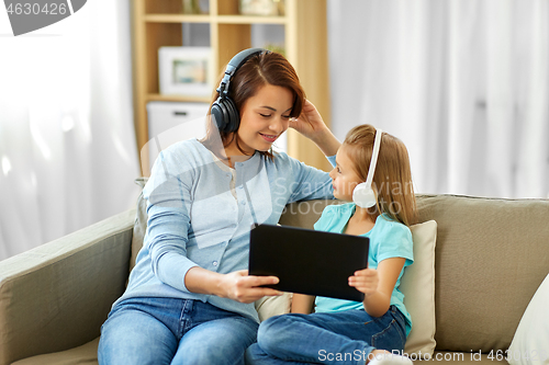 Image of mother and daughter listen to music on tablet pc