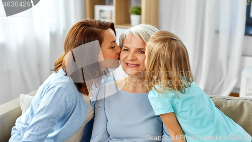 Image of mother and daughter kissing happy grandmother