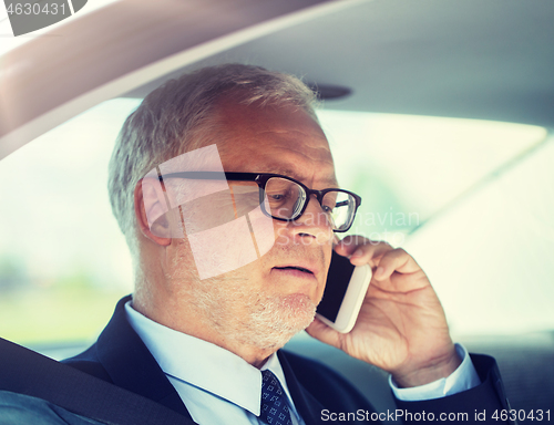 Image of senior businessman calling on smartphone in car