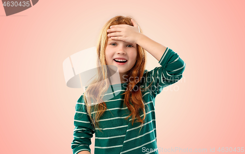 Image of smiling red haired girl holding to her head