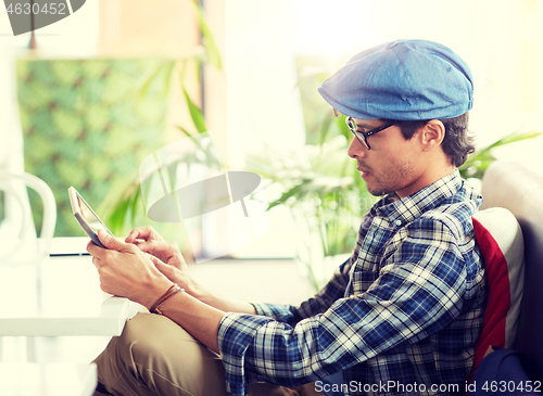 Image of man with tablet pc sitting at cafe table