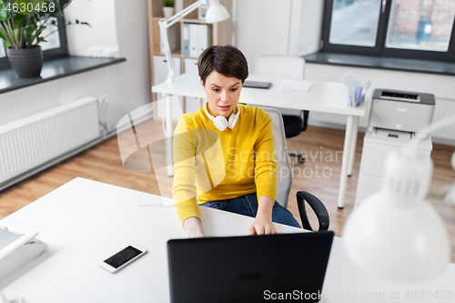 Image of businesswoman with laptop working at office