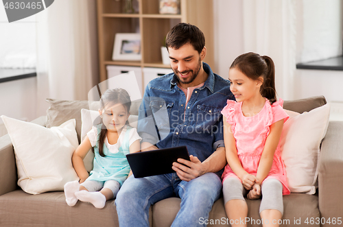 Image of happy father and daughters with tablet pc at home