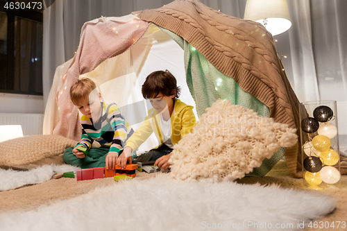 Image of boys playing toy blocks in kids tent at home