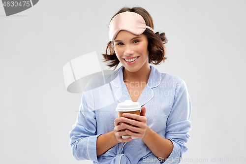 Image of woman in pajama and sleeping mask with coffee cup