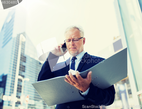 Image of senior businessman calling on smartphone in city