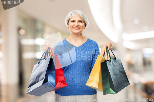 Image of senior woman with shopping bags over mall