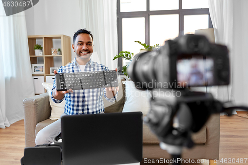 Image of male blogger with keyboard videoblogging at home