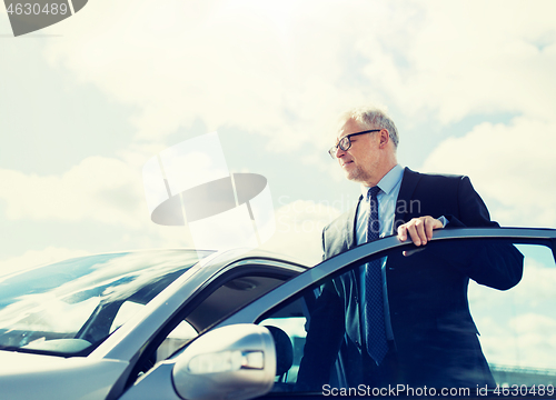 Image of senior businessman getting into car