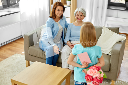 Image of grandmother, mother and daughter with flowers