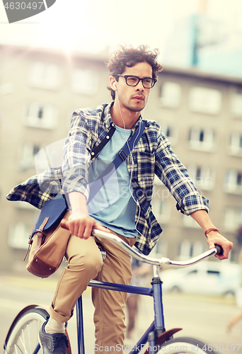 Image of young hipster man with bag riding fixed gear bike