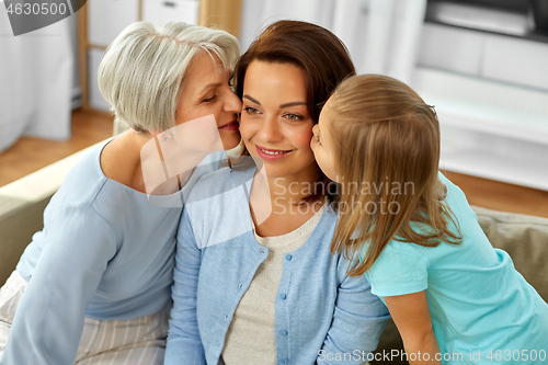 Image of grandmother and daughter kissing happy mother